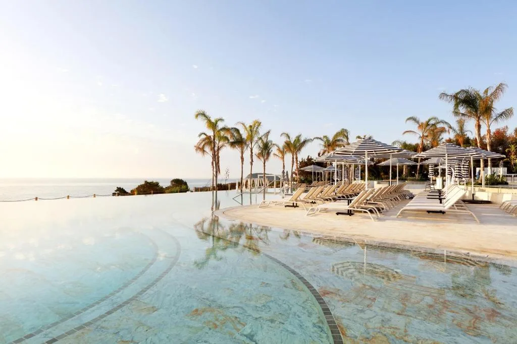 Piscine bordée de palmiers face à la mer, dans un hôtel des Baléares
