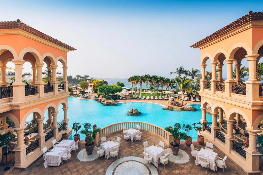 Hôtel de style colonial et sa piscine bordée de palmiers, à Tenerife