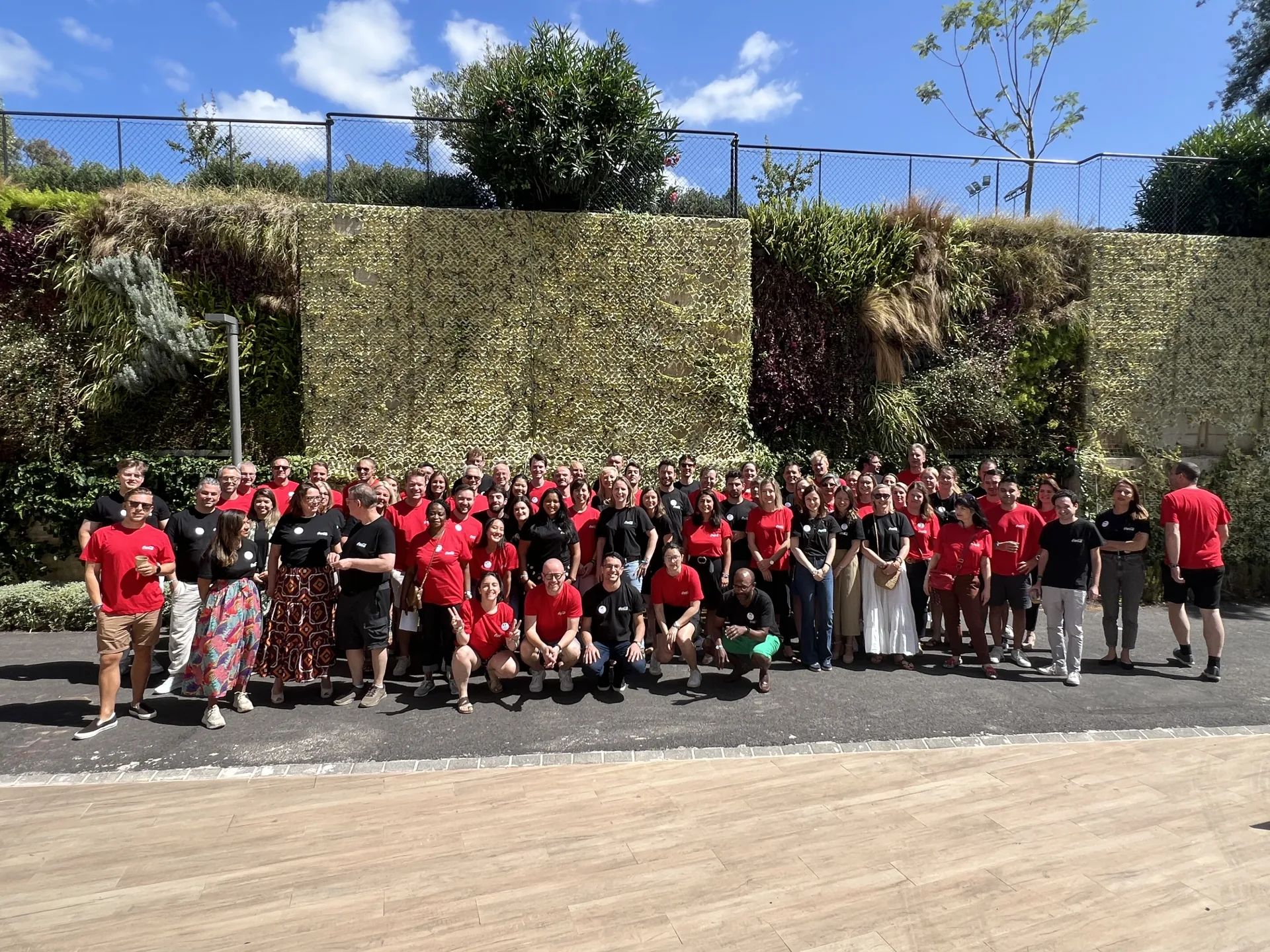 Photo de groupe d’un séminaire d’entreprise, participants en tenue rouge et noire