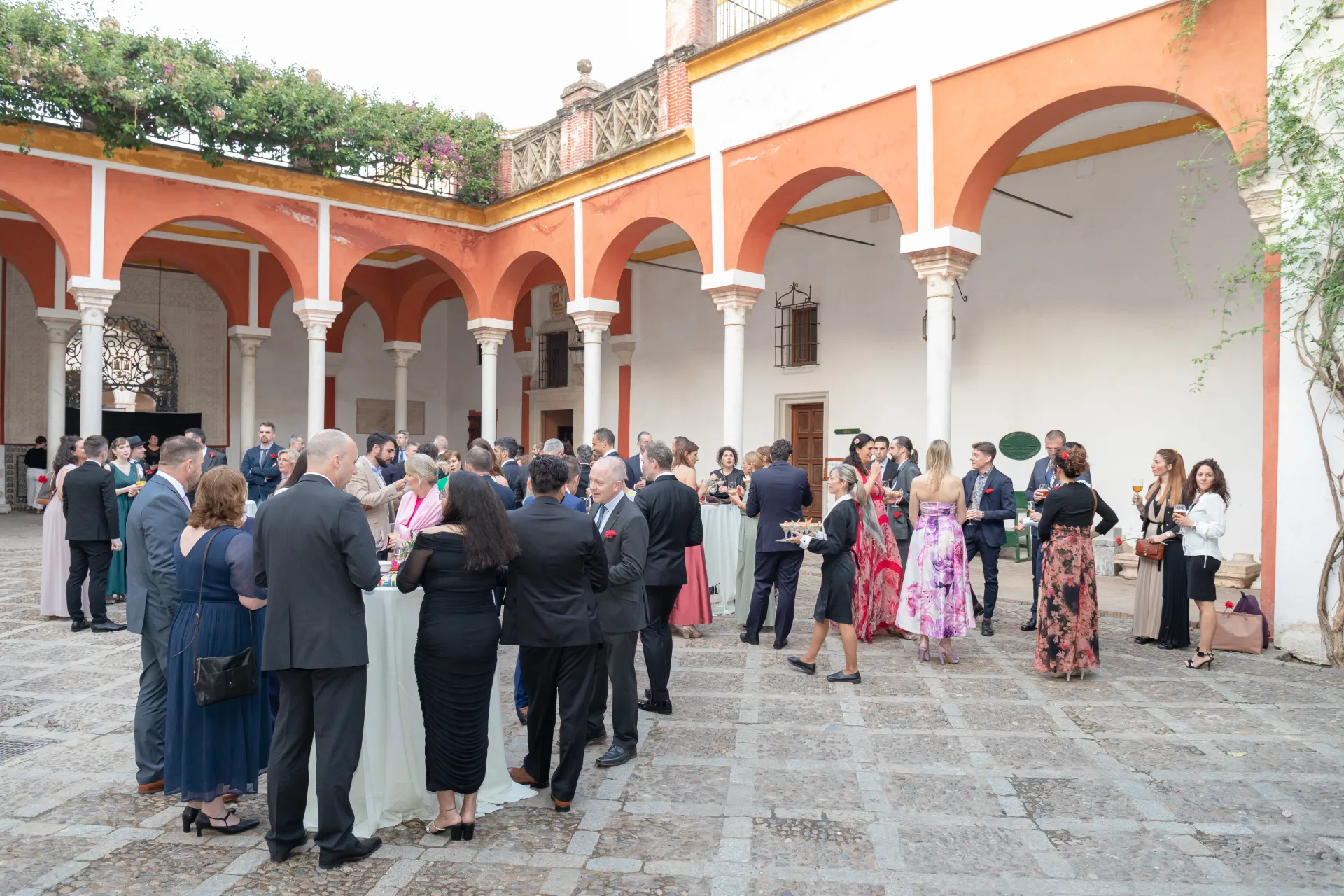 Cocktail d’invités dans le patio à arcades d’une demeure andalouse