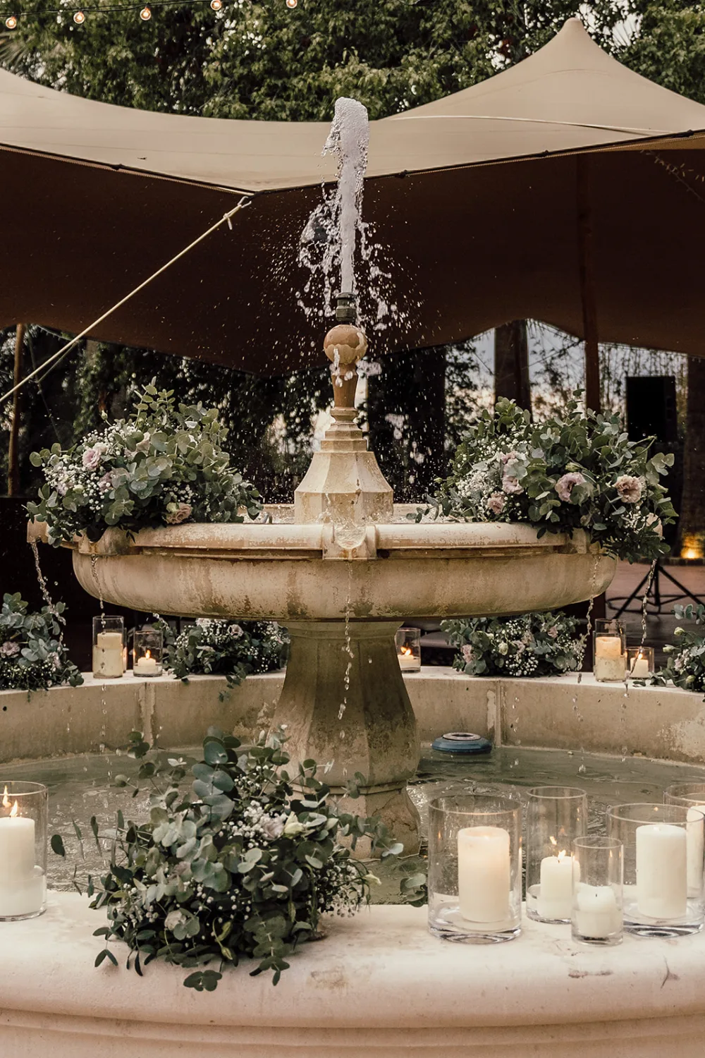 Fontaine décorée de fleurs blanches et de bougies pour une réception