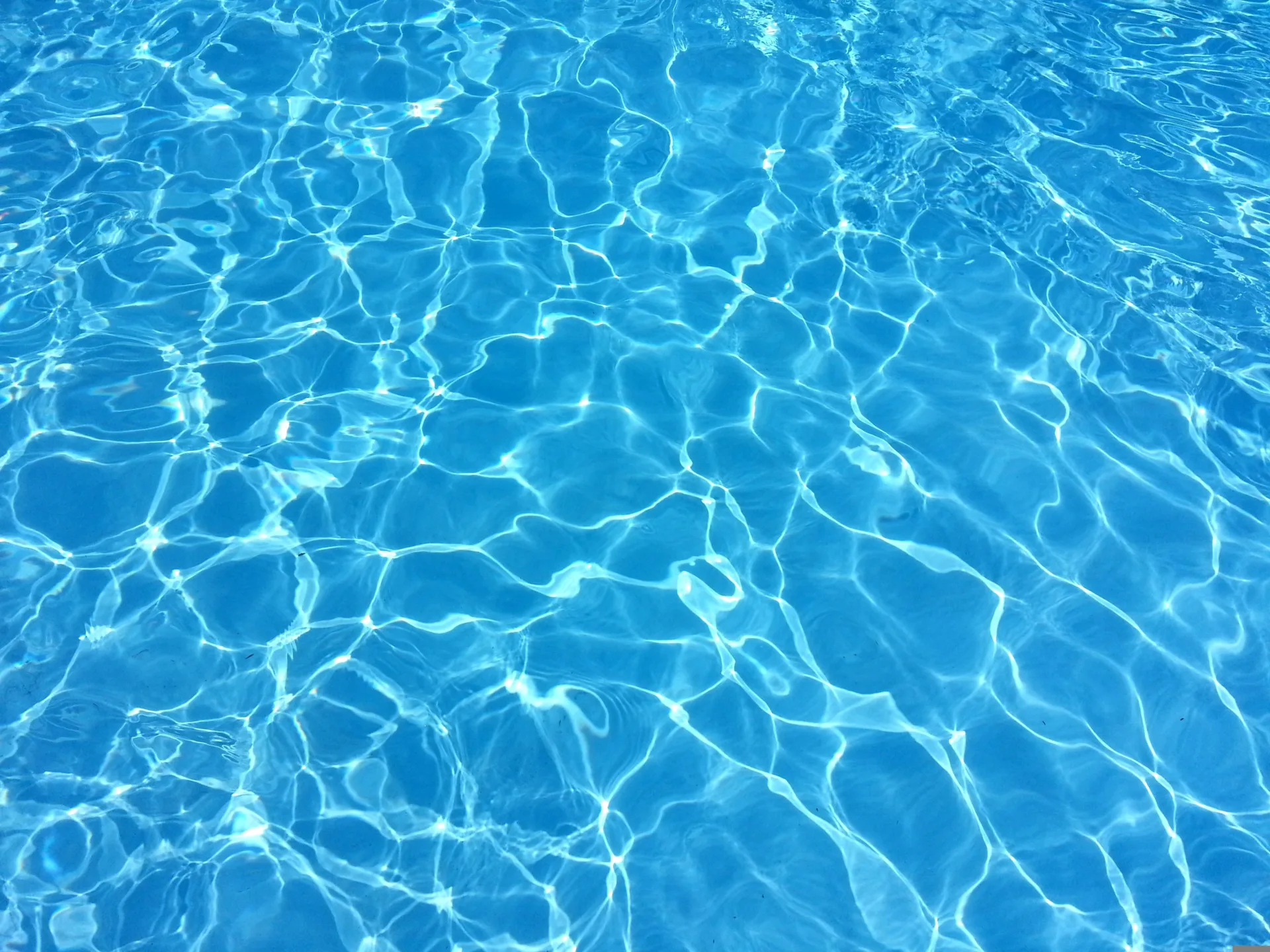 Surface d'une piscine ridée par la lumière