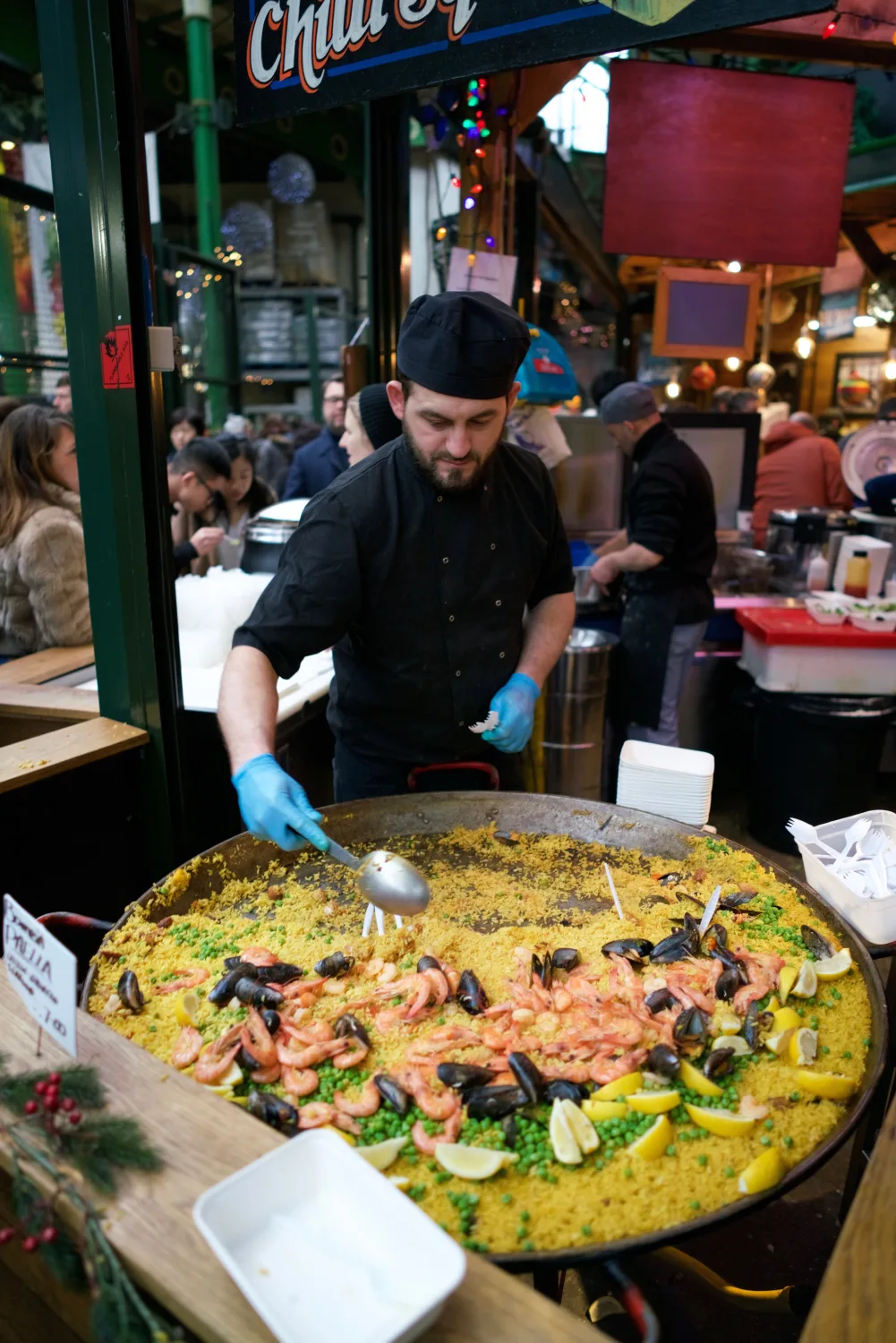 Cuisinier préparant une paella géante sur un marché