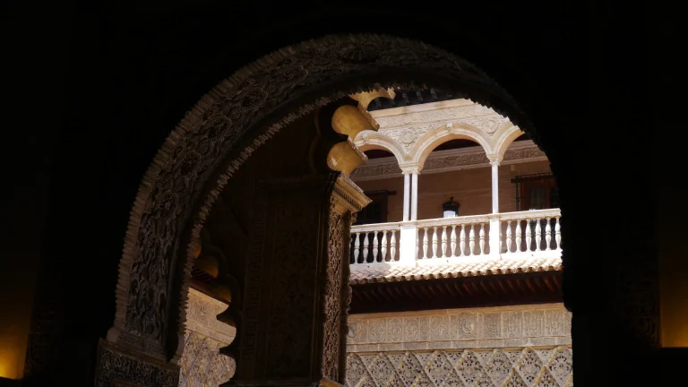 Arche mauresque ouvrant sur un patio andalou dans la pénombre