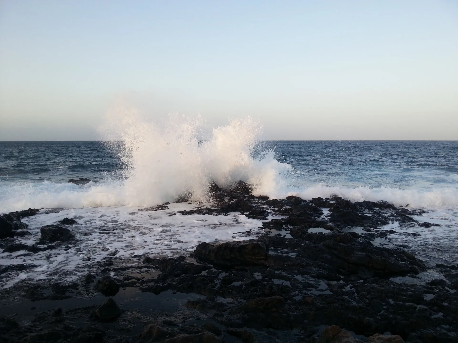 Vague se brisant sur les roches noires du littoral de Lanzarote