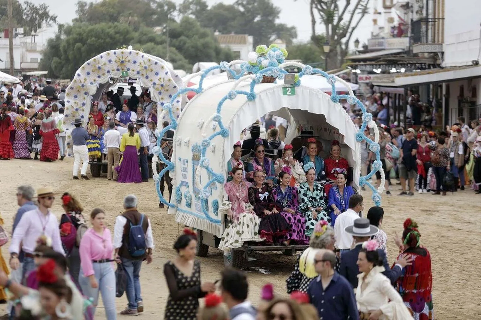 Char fleuri et foule en tenue andalouse pendant le pèlerinage d'El Rocío