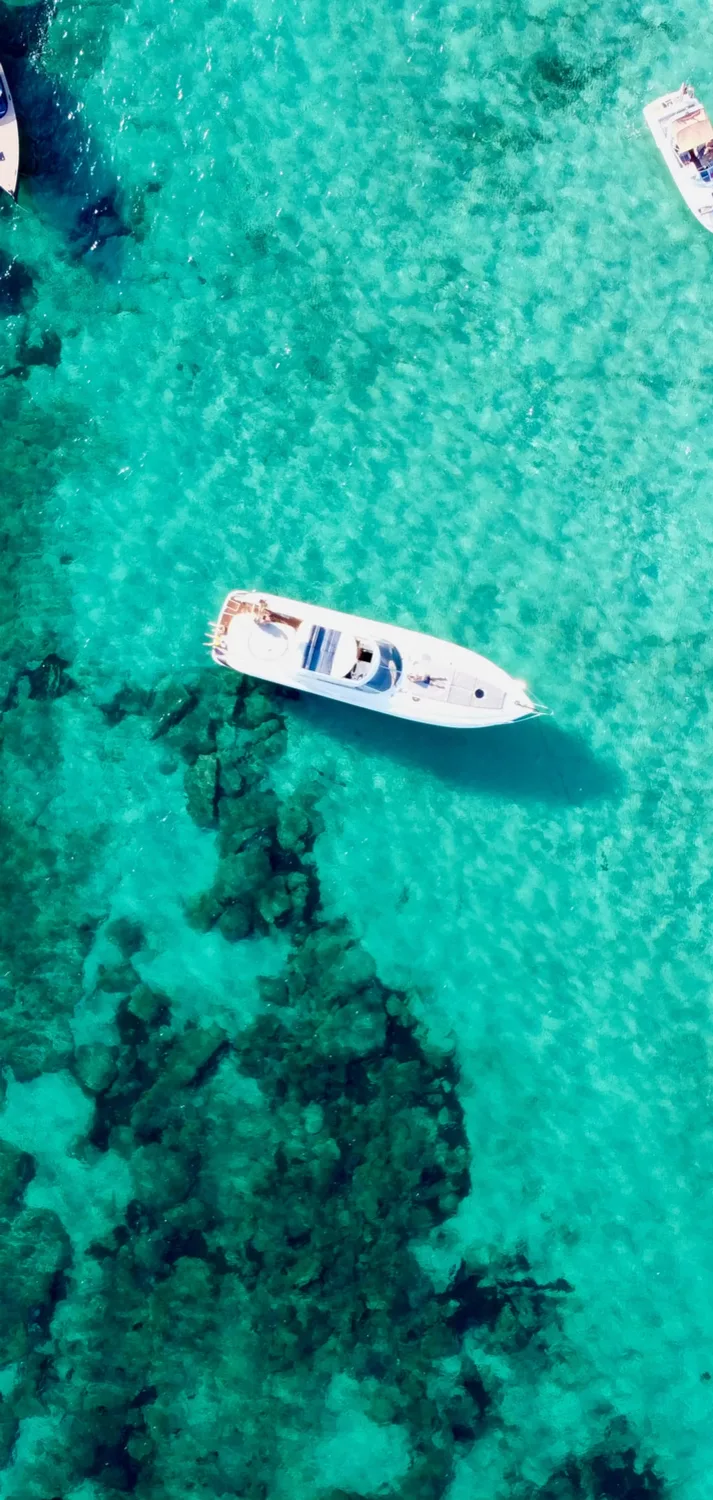 Catamaran au mouillage au-dessus d'un fond turquoise, vue aérienne