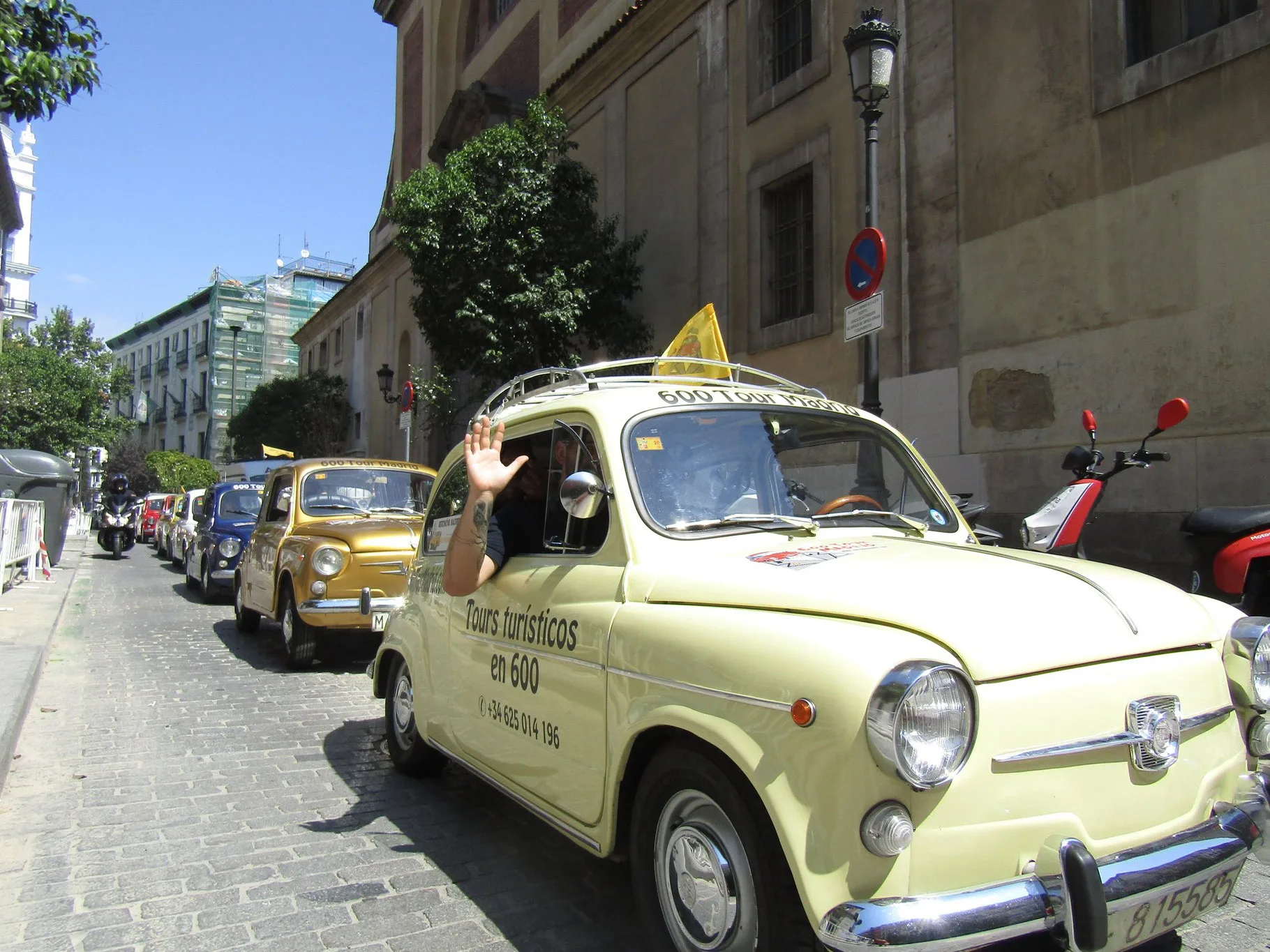 Voitures anciennes décorées alignées dans une rue de Madrid avant un rallye