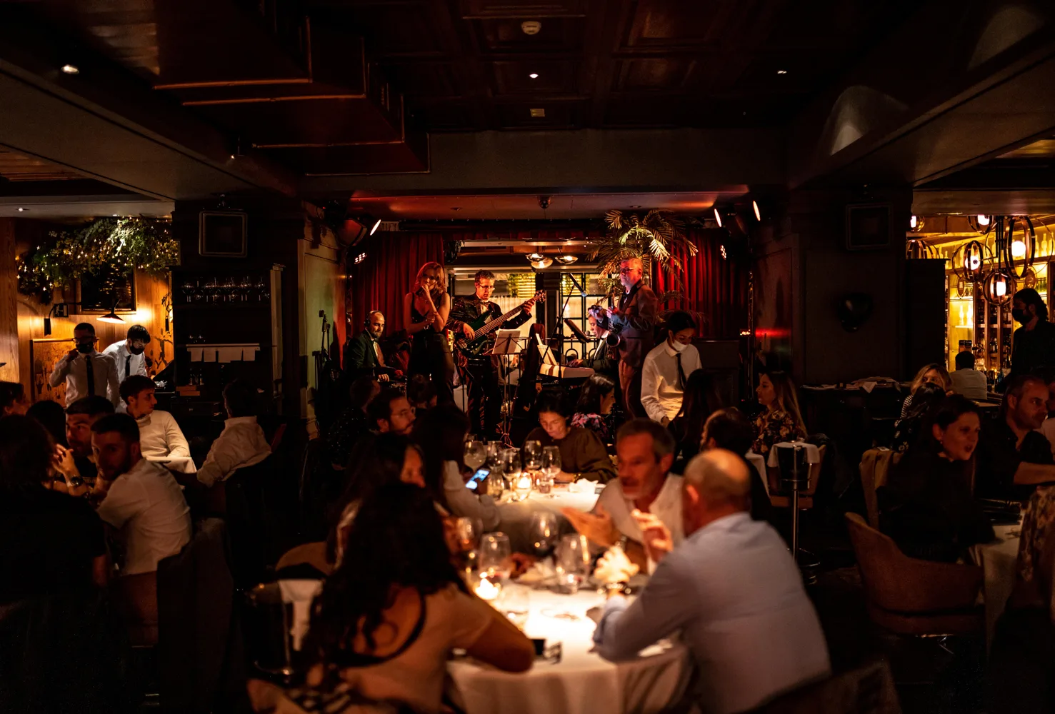 Taverne madrilène animée, convives attablés dans une lumière chaude