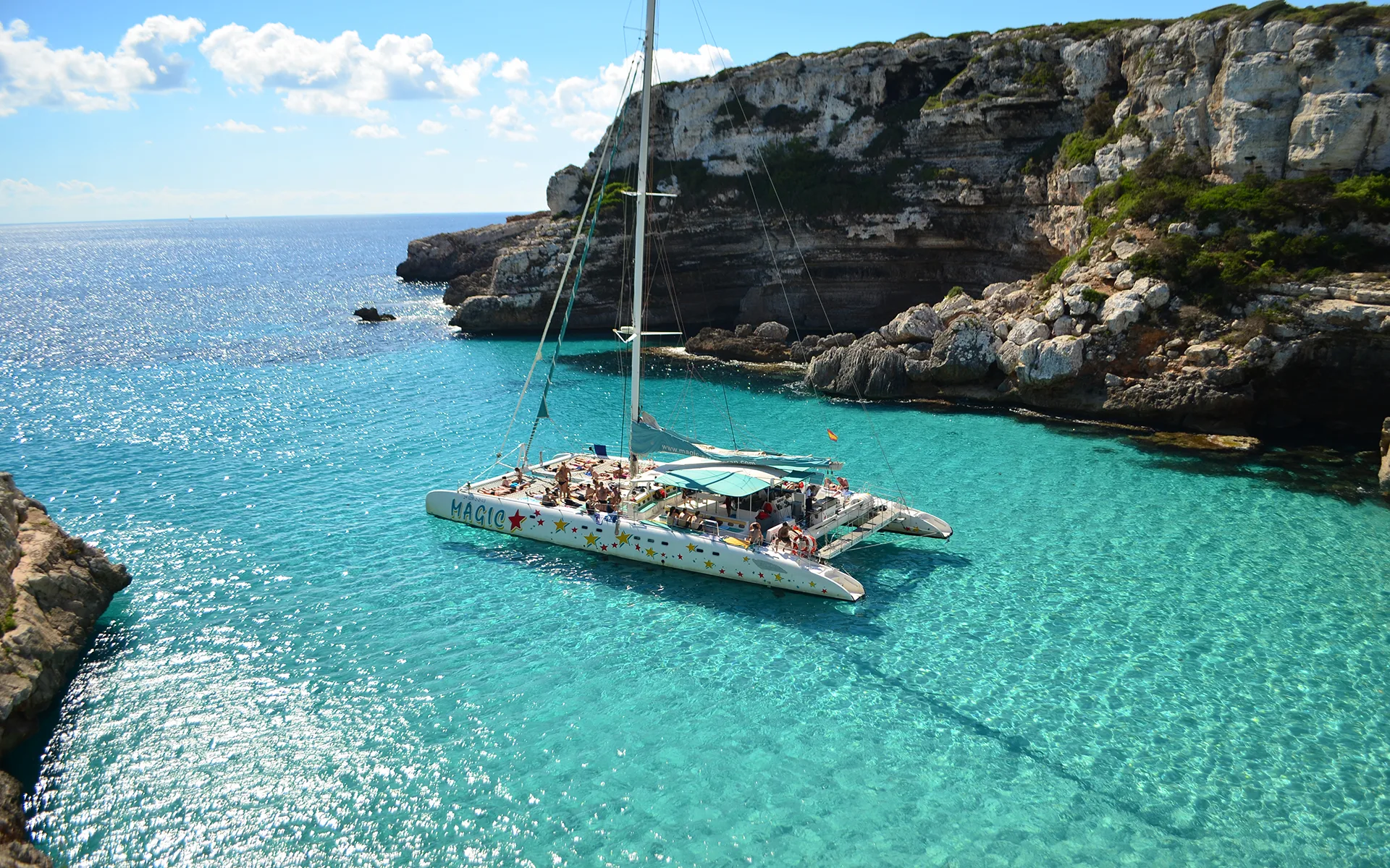 Catamaran au mouillage dans une crique turquoise de Majorque