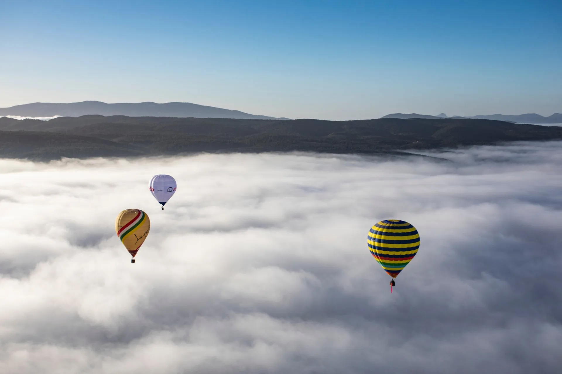 Montgolfières s'élevant au-dessus d'une mer de nuages