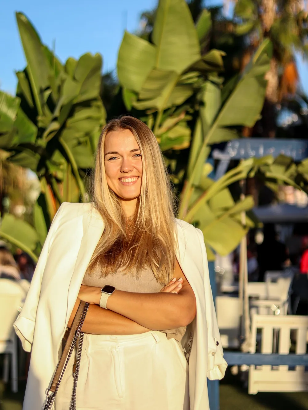 Karlina, chargée des relations clients chez Oleventia, devant des bananiers au soleil couchant